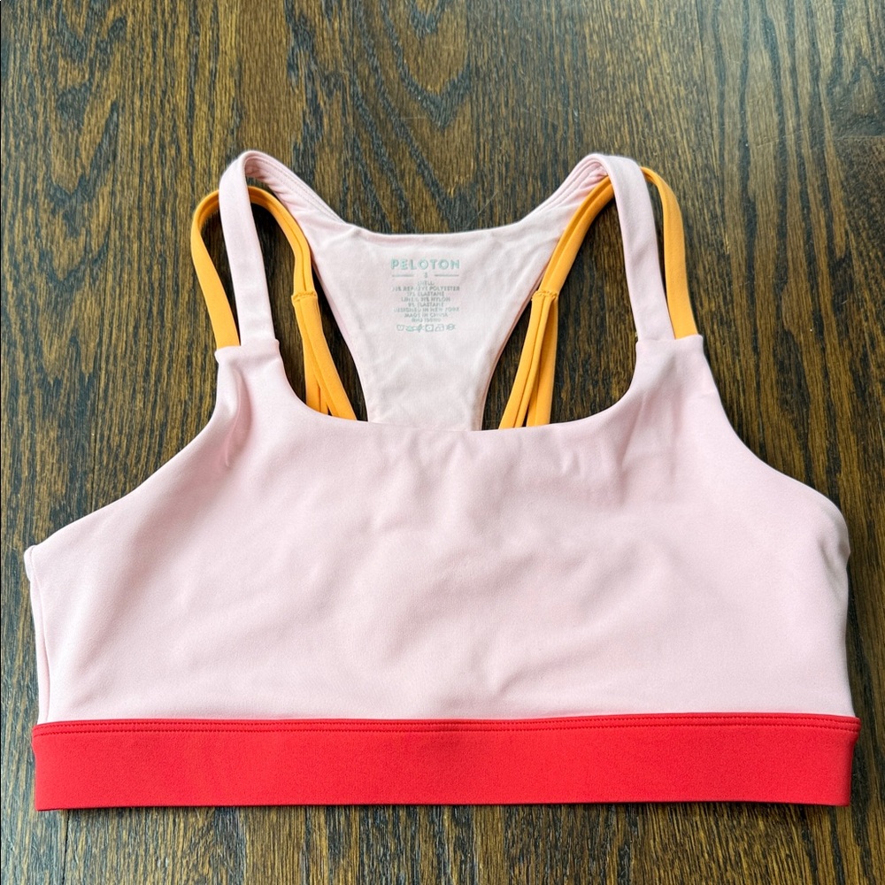 Peloton Pink Sports Bra with Red Band and orange Straps. Size small